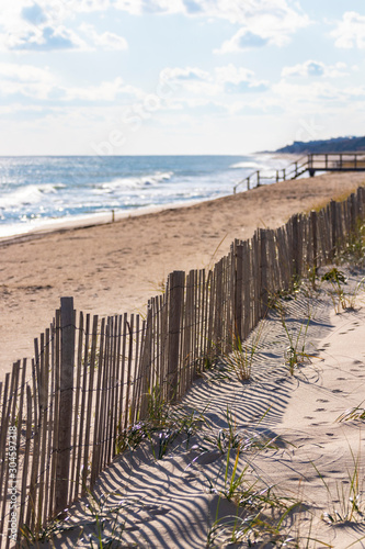 Protective fencing along sand dunes of public/private beach at the ocean