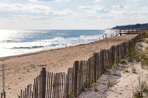 Protective fencing along sand dunes of public/private beach at the ocean photo