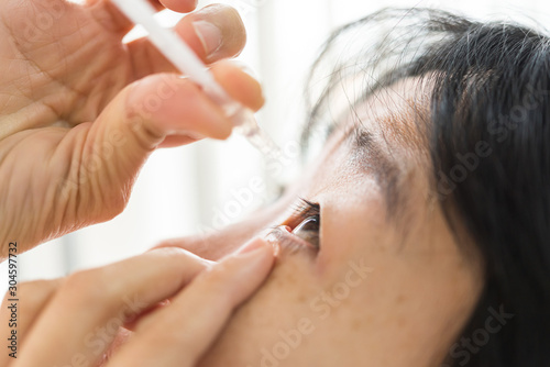 Fototapeta Naklejka Na Ścianę i Meble -  Woman use eye drop, artificial tears to the eye