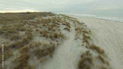 Drone flying low over the dunes at a Dutch beach. Ending up high above ground.