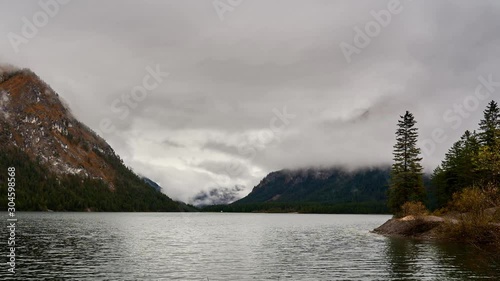 Swirling clouds slowly reveal alpine peaks in Heiterwangersee, a lake in Tirol, Austria photo