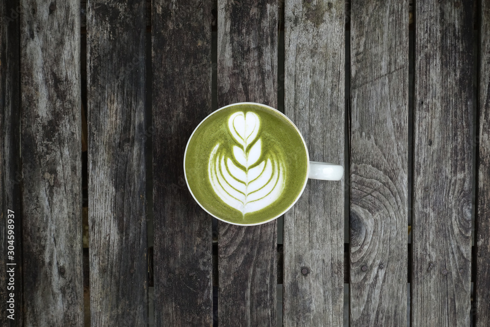 A cup of green tea matcha latte on wooden background A cup of green tea matcha latte on wooden background