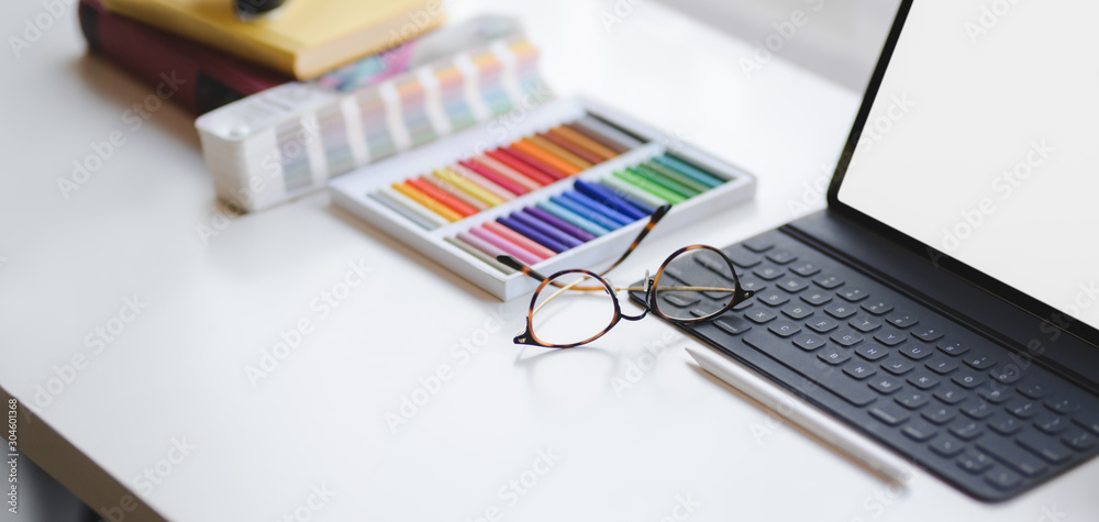 Cropped shot of modern designer office room with blank screen digital tablet and office supplies on white table Cropped shot of modern designer office room with blank screen digital tablet and office supplies on white table