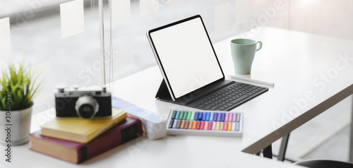 Cropped shot of modern graphic designer workplace with blank screen digital tablet, camera and office supplies © bongkarn