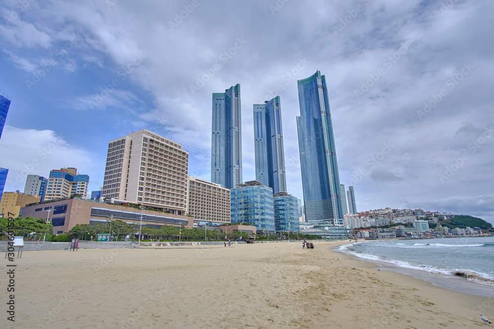 Scenic view of awesome sand beach, sea and skyscrapers in Busan in South Korea. Beautiful summer cloudy look of relax place in resort city in Republic of Korea