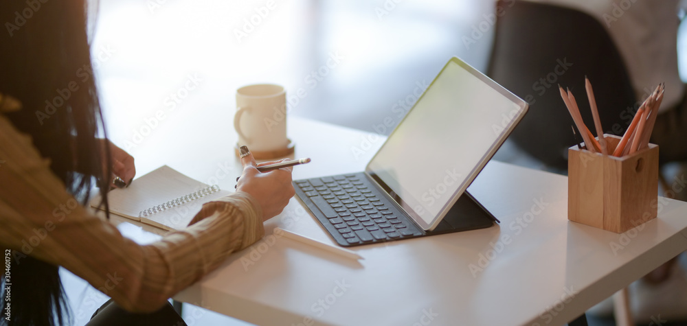 Cropped shot of young female designer drafting her project with digital tablet in modern office Cropped shot of young female designer drafting her project with digital tablet in modern office