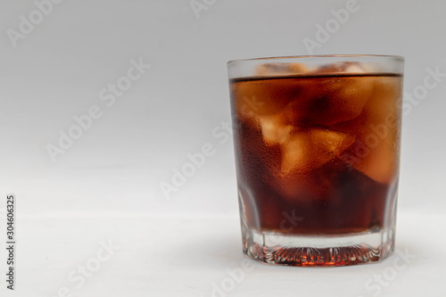 A close up in a glass of cold cola,  isolated white background