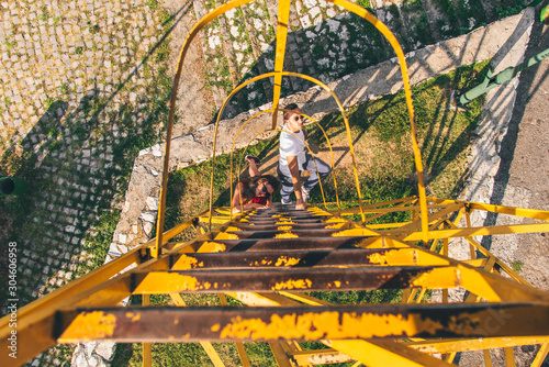 Friends having fun climbing metal ladder