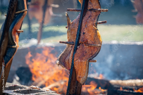 Salmon being  grilled over an open fire using a traditional native american technique at an event in Southern Oregon