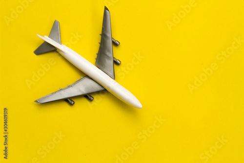 Airplane on yellow background with space for text. The concept of travel or vacation is viewed above.
