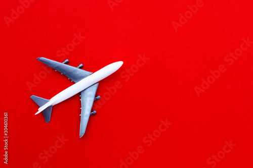 airplane stand on red paper background. modern plane isolated on red backdrop. travel and transportation idea.