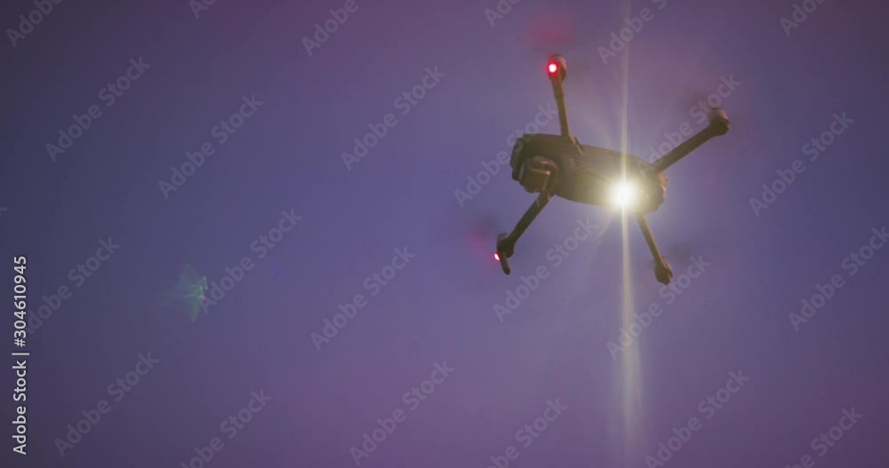 UAV drone orbiting in the sky shining a search spotlight at night, drone technology used for the good of humanity UAV drone orbiting in the sky shining a search spotlight at night, drone technology used for the good of humanity