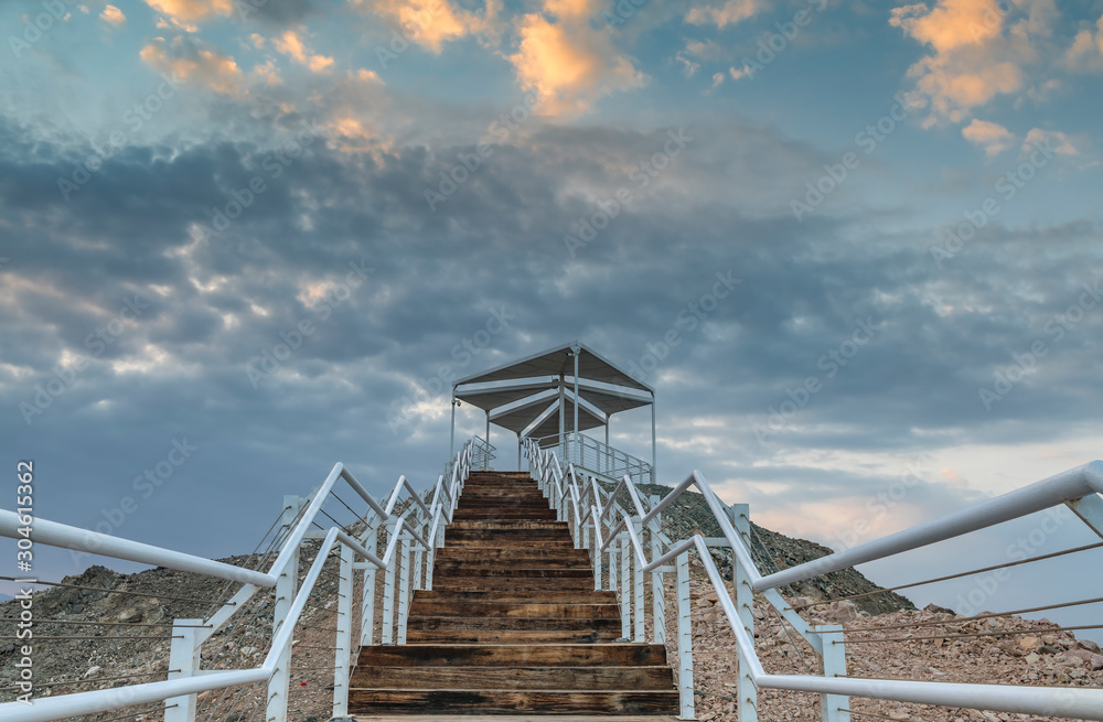 Fototapeta premium Sunrise at top of mount and stair-steps and pergola, photo taken in nature public park, vicinity of Eilat - famous tourist resort and recreational city in Israel