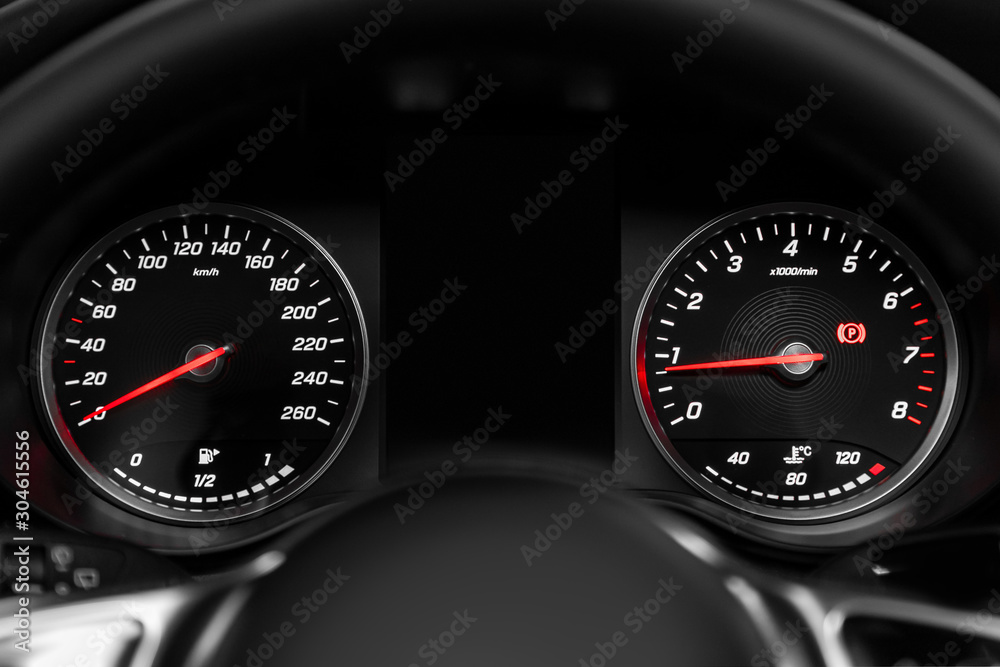 close-up of round dashboard, speedometer and tachometer with white backlight. modern car interior.