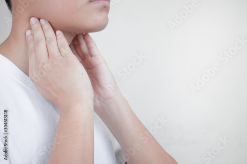 Sore throat, person holding the neck due to climate change. Health concept.