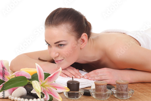 Young woman on massage table with candles