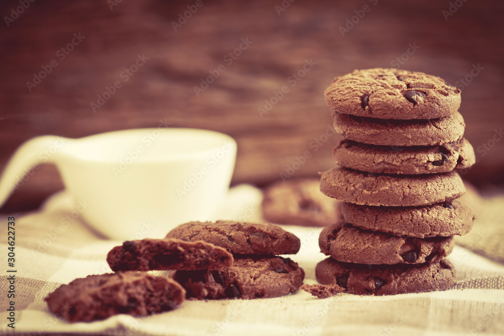 Close up stacked chocolate chip cookies on napkin with wooden background Close up stacked chocolate chip cookies on napkin with wooden background