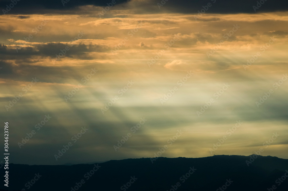 Fototapeta premium Sunset, sun rays seep through the clouds