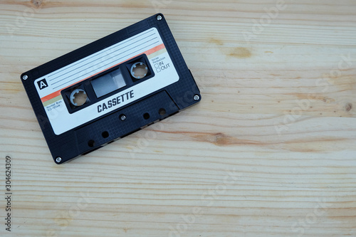 Close up vintage and old audio cassette tape on wooden floors. Accessories for the 70-80-90's era.