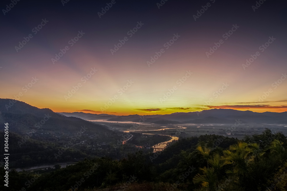 Fototapeta premium Mountain view misty morning above Kok river and Tha Ton City around with sea of mist and purple sky background, sunrise at Wat Tha Ton, Tha Ton District, Fang, Chiang Mai, northern of Thailand.