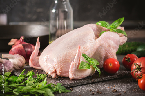 Whole raw chicken on a rustic background