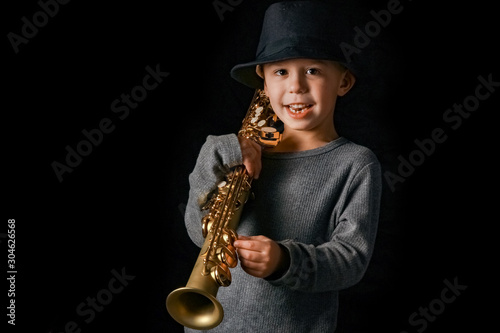 happy child plays saxophone in studio photo