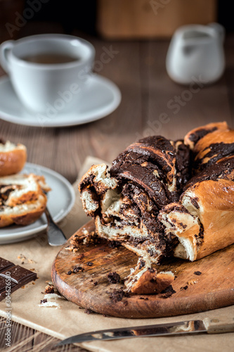 Swirl cake with chocolate on wooden background