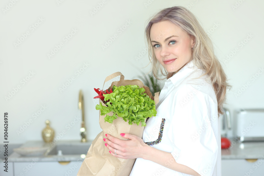 young positive smiling woman with vegetables in the kitchen young positive smiling woman with vegetables in the kitchen