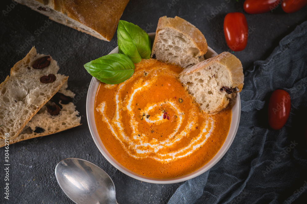 Tomato soup with fresh basil, served with cream and sourdough bread