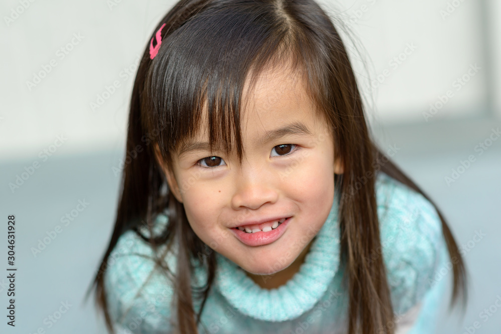Playful friendly little girl leaning forwards Playful friendly little girl leaning forwards