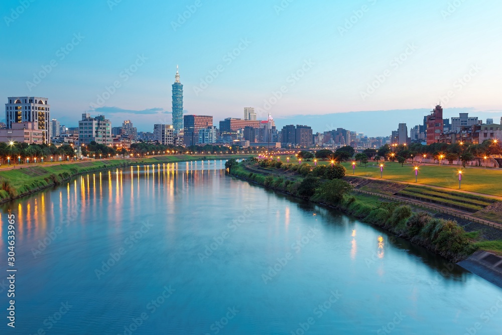 Beautiful riverside scenery of busy Taipei City with view Taipei landmark Tower,  Keelung River and downtown area at dusk ~ A Blue and Gloomy evening in Taipei