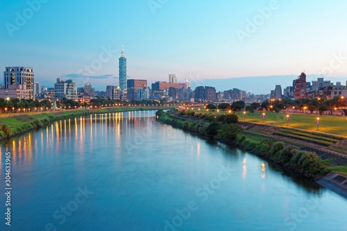 Beautiful riverside scenery of busy Taipei City with view Taipei landmark Tower,  Keelung River and downtown area at dusk ~ A Blue and Gloomy evening in Taipei