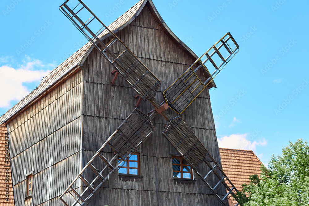 Photo of an old windmill with wooden blades blue sky. Photo of an old windmill with wooden blades blue sky.