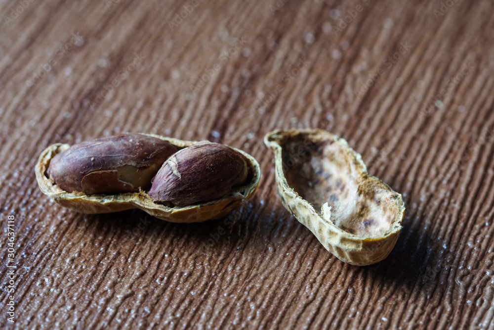 Peanut also known as ground nut with its shell over brown background.