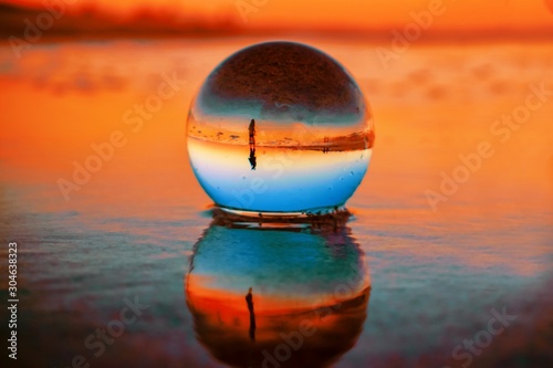Fototapeta Naklejka Na Ścianę i Meble -  Beautiful selective focus shot of a crystal ball reflecting the breathtaking sunset