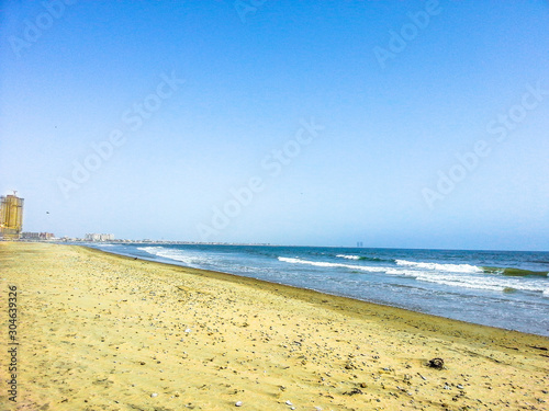 breathtaking view of sandy beach and rocks with sea and sky in the background 