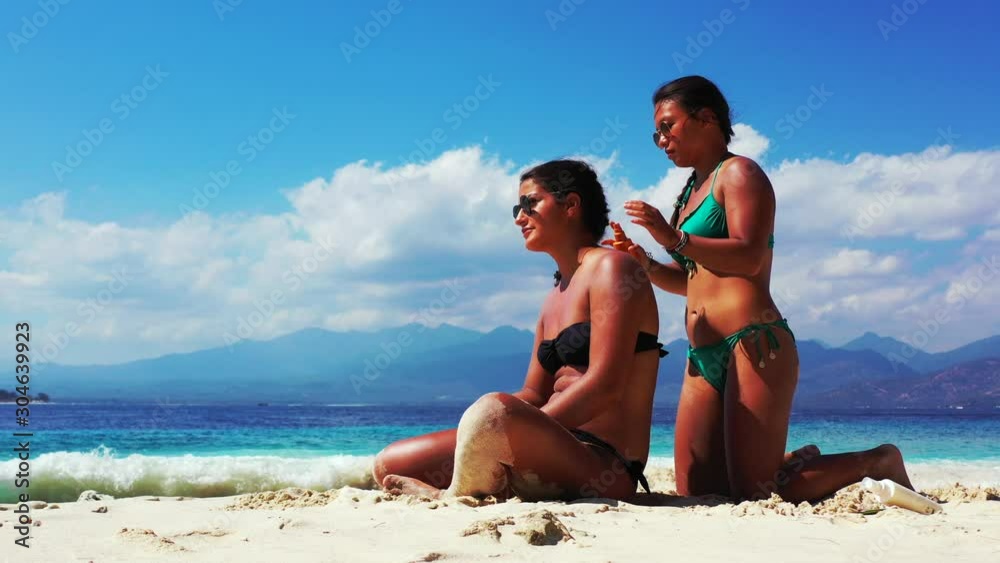 Gorgeous Ladies Enjoying Their Vacation In The Beach Of Singapore While Applying Sunblock On Their Skin - Close Up Shot Gorgeous Ladies Enjoying Their Vacation In The Beach Of Singapore While Applying Sunblock On Their Skin - Close Up Shot