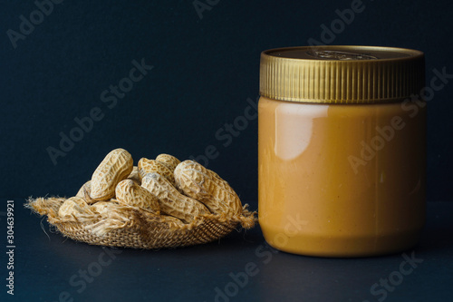 Peanut butter with the peanuts over black background.this peanut also kown as ground nut. selective focus photo