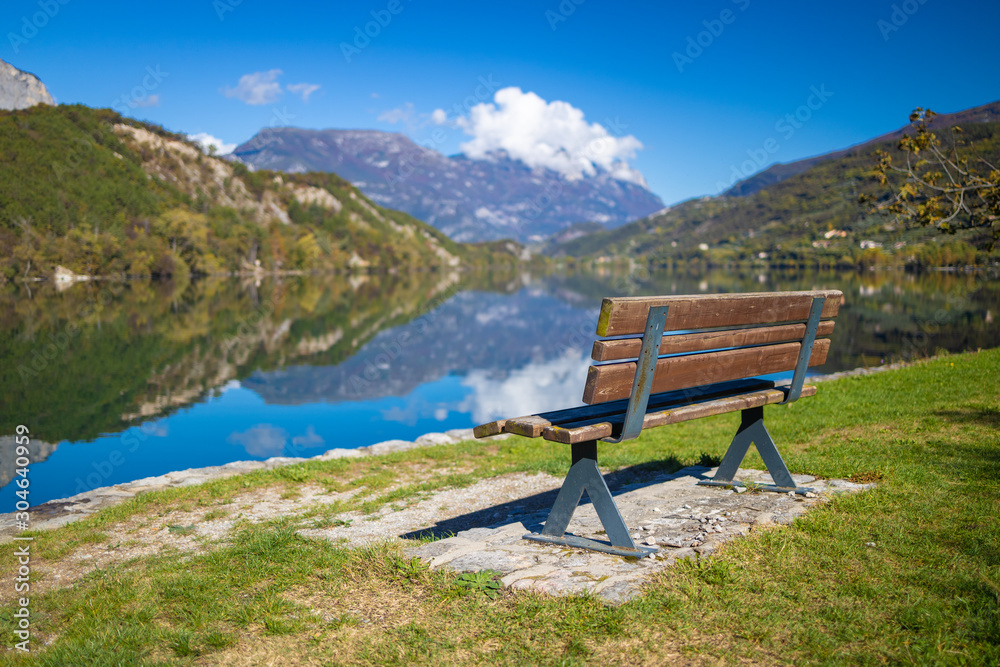 Lago di Cavedine beautiful lake. Wooden bench in focus. Italy. Arco