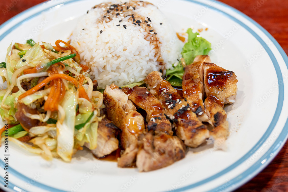 Grilled Chicken teriyaki rice. Rice topped with teriyaki chicken sprinkled with chives, sesame seeds. Rice with teriyaki chicken grill or teriyaki don in Japanese style set and ready to eat.