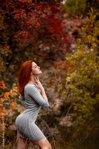 Beautiful young woman enjoys the autumn warmth