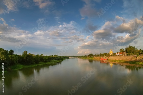 river view evening of Buddhist Temple on the bank of Mae Klong river with cloudy sky background, Wat Yai Nakhon Chum, Nakhon Chum, Ban Pong District, Ratchaburi, Thailand.