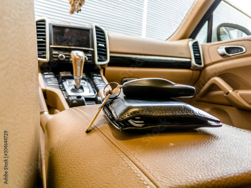 A Car Key And a Wallet are kept on Console of a Luxury Car with luxury Interior 