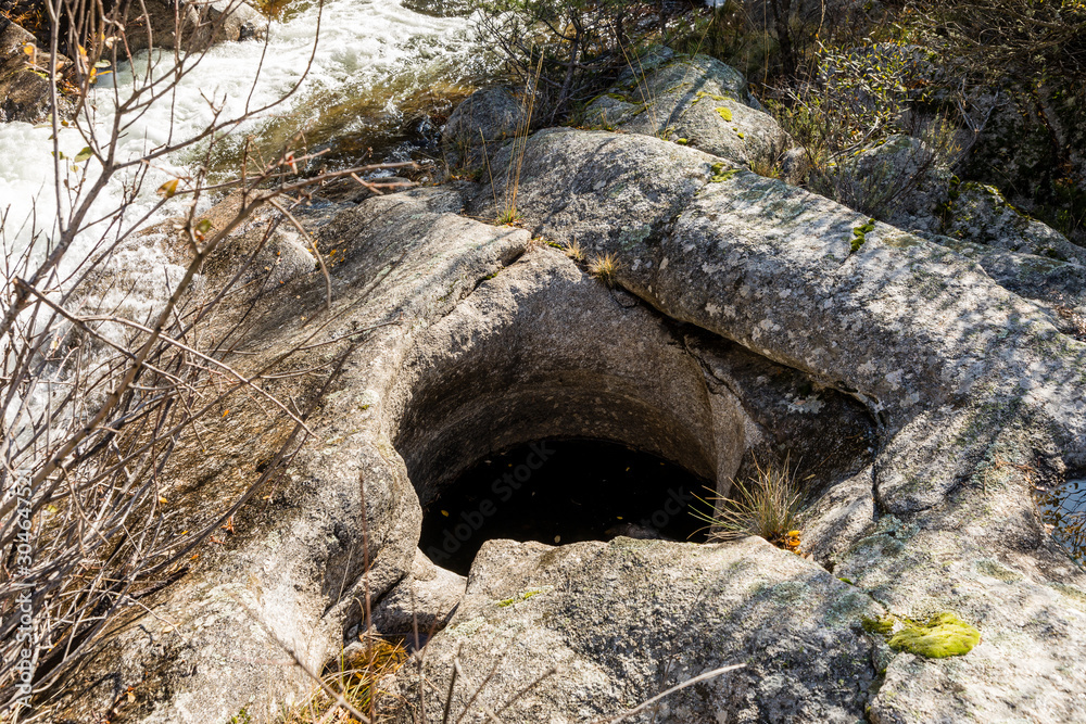 Circular shapes created in granite rock by erosion of river water in La Pedriza, Madrid Circular shapes created in granite rock by erosion of river water in La Pedriza, Madrid