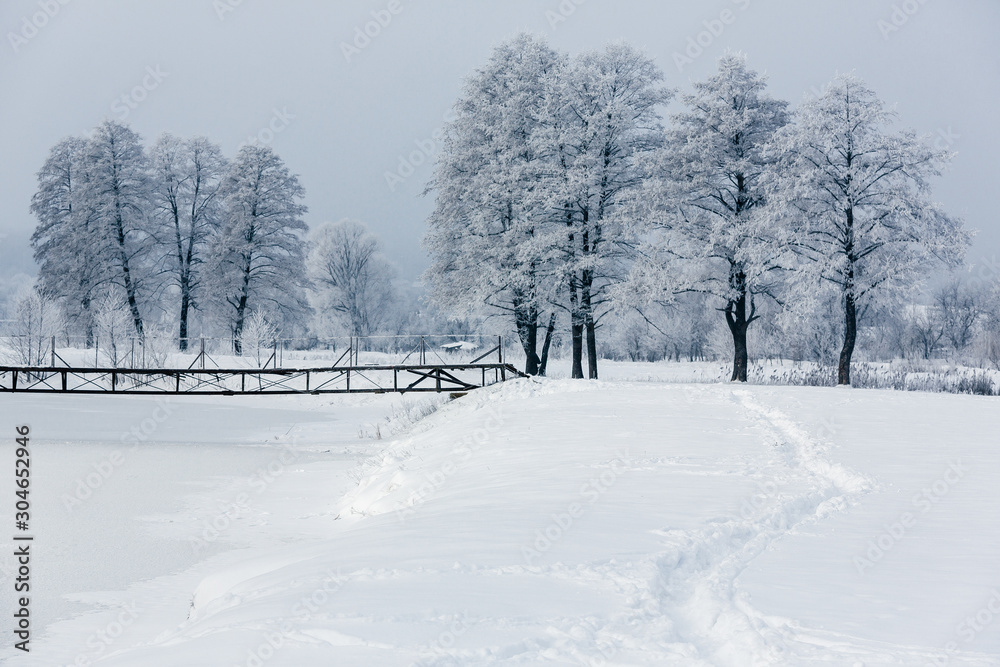 winter landscape with trees and snow, hoarfrost on trees, bridge over the river, path in the snow winter landscape with trees and snow, hoarfrost on trees, bridge over the river, path in the snow