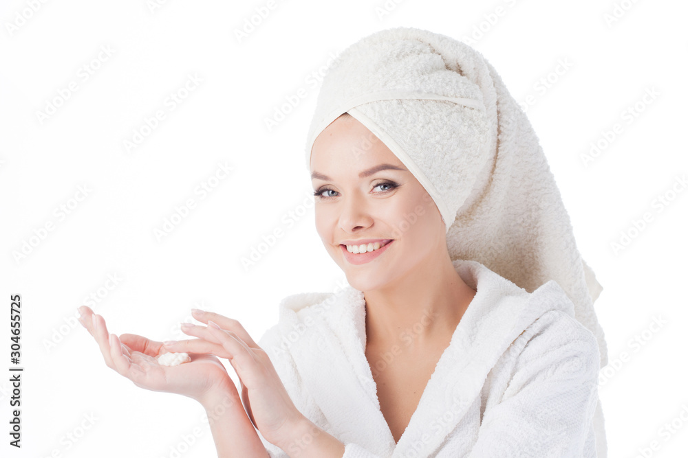 To use the cream after a shower. Portrait of a young attractive woman in a Bathrobe and a towel on her head. To use the cream after a shower. Portrait of a young attractive woman in a Bathrobe and a towel on her head.