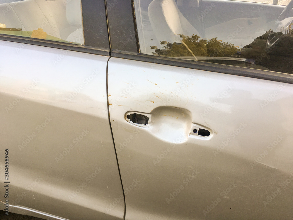 thieves removed the handle and locker of a silver car   