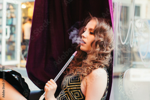 a young lady with curls and a hookah
