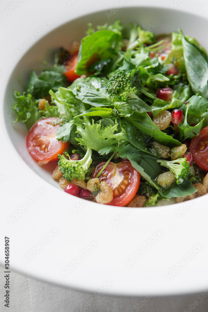 Homemade green broccoli salad with grapes, onion and tomato