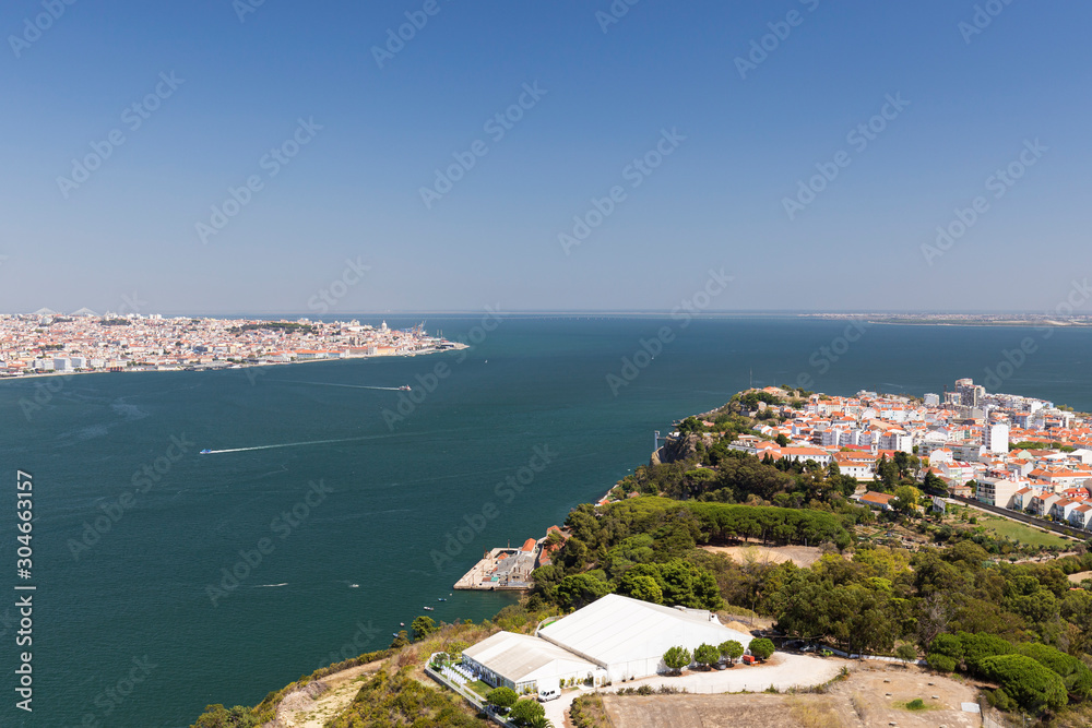 Lisbon and Almada cities and Tagus River in between in Portugal viewed from above on a sunny day in the summer.